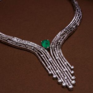 Luxurious diamond necklace featuring an exquisite emerald on a brown background.